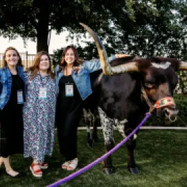 Attendees pose at Meetings Today LIVE! National next to bull in San Antonio