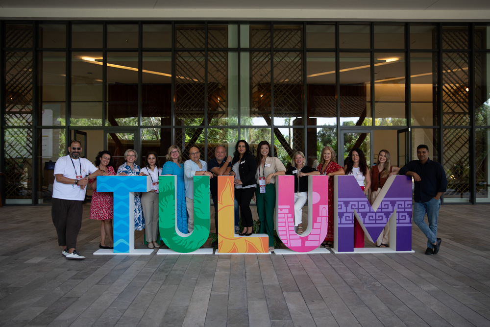 SITE Global attendees pose with a Tulum sign outside of the Hilton Tulum Riviera Maya All Inclusive Resort convention center. Photo Credit: Joey Woolridge