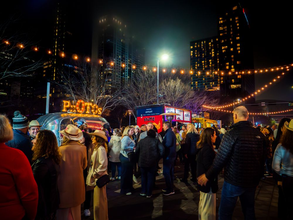 Photo of people gathered in front of food trucks at Avenida Houston.