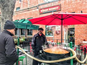 Photo of two men in Boise's Basque District, overlooking a giant pan of paella.