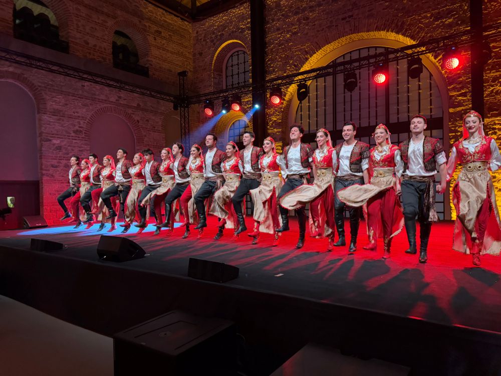 A line of traditionalTurkish dancers on stage.