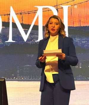 Dr. Elif Balcı Fisunoğlu speaking in front of an MPI logo.