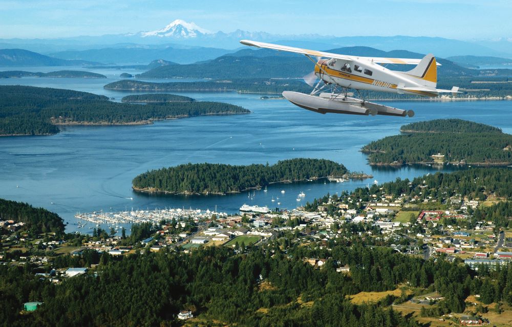 Photo of Kenmore Air seaplane flying above islands in Washington state.