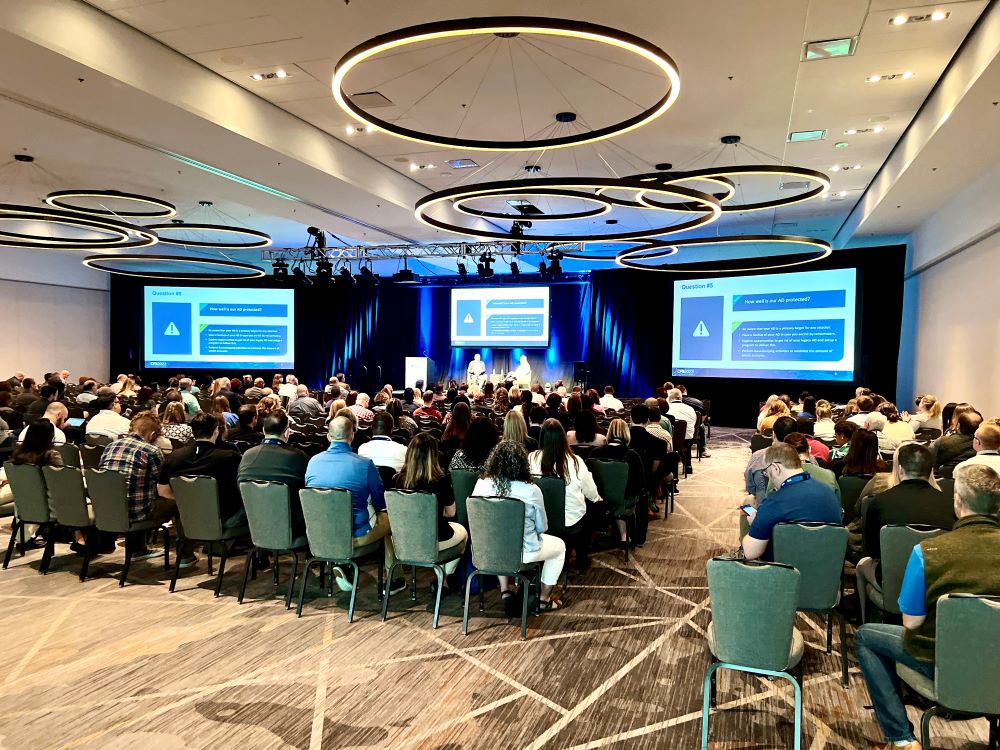 Photo of a meeting room full of people watching a presentation.