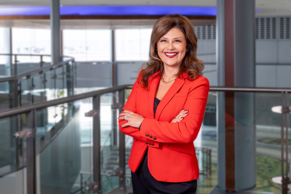 Photo of Aracelly Delgadillo in a red blazer in an office setting.