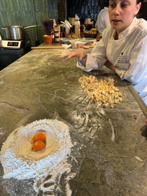 Photo of a chef making Turkish pastries with two raw eggs in the foreground.