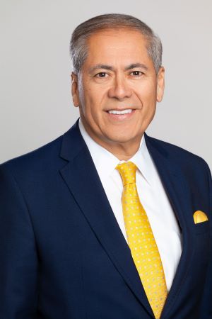 Photo of Javier Cano with a yellow tie and blue suit.