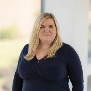 Photo of Jill Blood, standing in a blue dress.