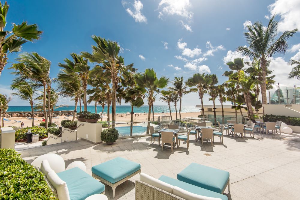 Photo of  La Concha Resort, with the beach and palm trees in the background.