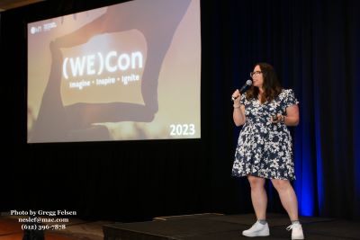 Mandi Graziano speaking on stage at (WE)Con 2023. Credit: Gregg Felsen.