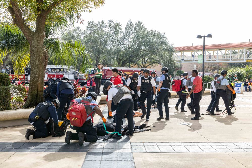 Photo of security personnel assisting an actor pretending to be injured.