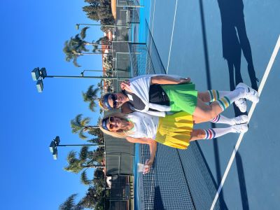 Photo of two women in 1980s fashion on pickleball court.