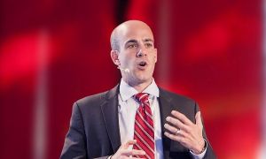 Photo of Scott Steinberg speaking in front of a red background.