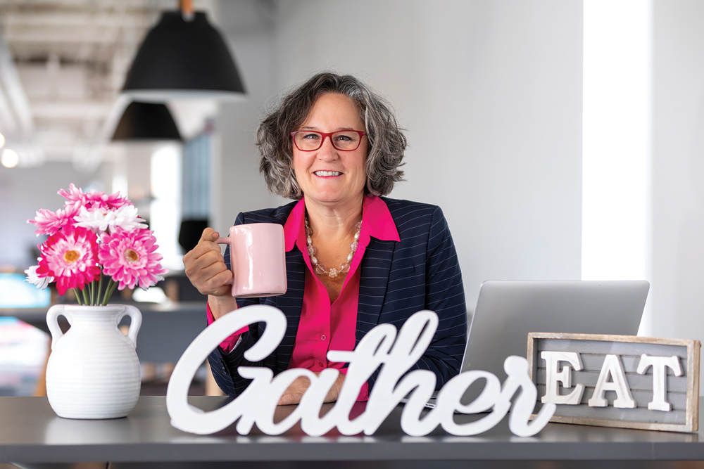 Photo of Tracy Stuckrath, sitting with a cup of coffee, with the words Gather and Eat in the foreground. 