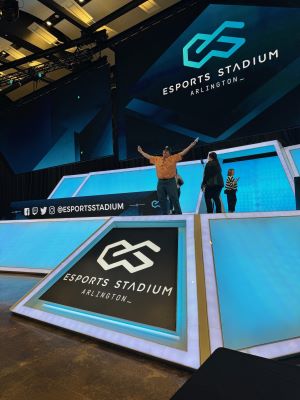 Photo of Tyler Davidson on stage at Esports Arlington, with arms raised triumphantly.