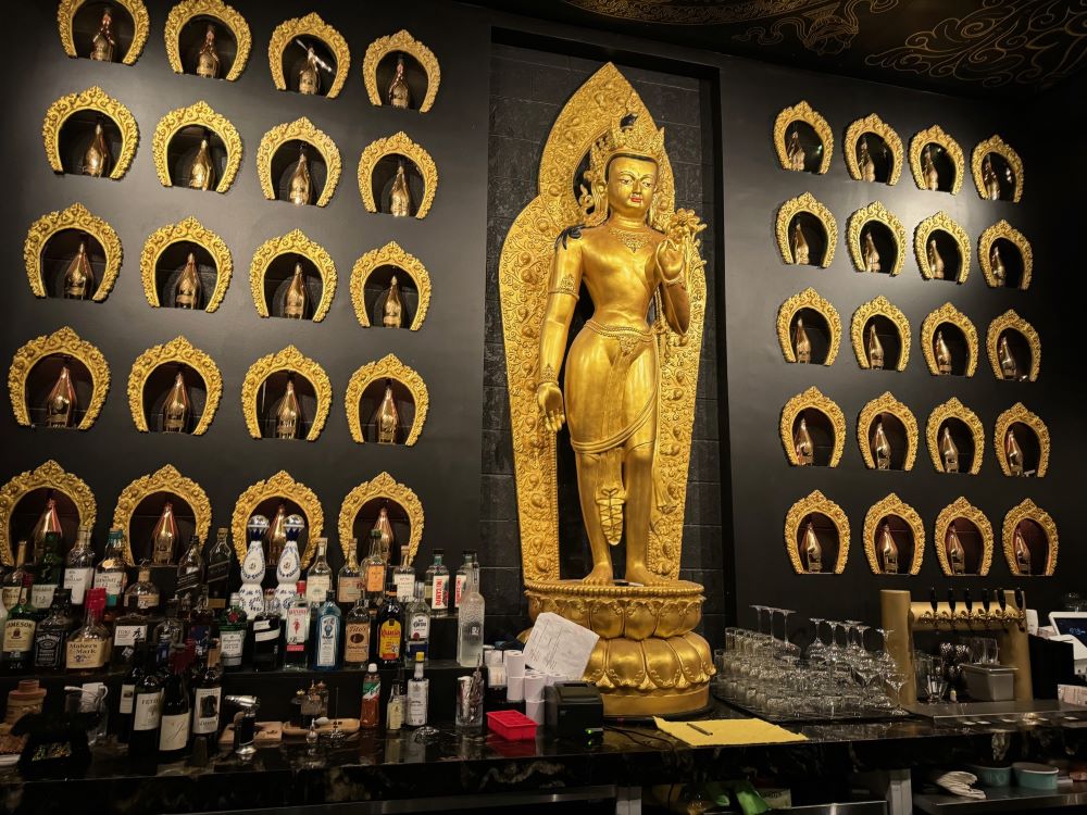 Photo of large Buddha statue behind bar at Taipo restaurant.