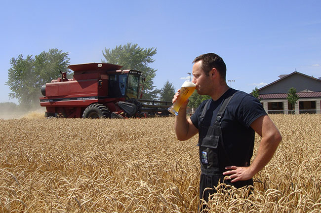 One of the Brewers at Riggs Brewery Enjoys a Beer in the Field