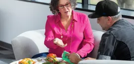 Photo of Tracy Stuckrath sitting on a couch, talking with chef.