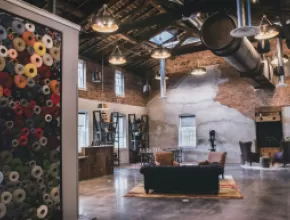 Photo: The hotel complex is uniquely Amana from the customer’s first step into the lobby. The design team incorporated old equipment from the mill. On the left, the yarn wall is a nod to the woolen production that still occurs on site. Credit: Sara Montgomery