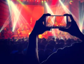 Someone recording a concert with a phone.