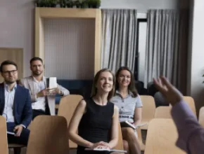 Group of people sitting in chairs listening to a speaker.