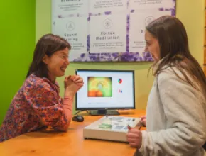 Dami Kim (left), director of Body & Brain Wellness, performing an aura reading on Taylor Smith (right)