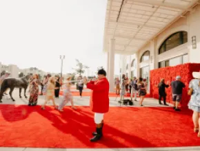 Photo of trumpeter in red coat outside MPI WEC opening reception at Churchill Downs.