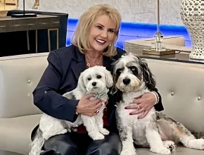 Photo of Anna Marie Presutti with two dogs on her lap.