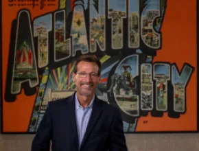 Gary Musich stands in front of Atlantic City mural