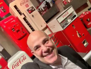 image of futurist Scott Steinberg standing in front of antique Coca-Cola vending machines.