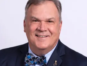 Roger Ricard in a dark blue suit with a checked bow tie.