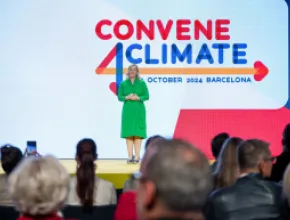 EMEA leader in green dress speaking on main stage