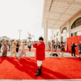 Photo of trumpeter in red coat outside MPI WEC opening reception at Churchill Downs.