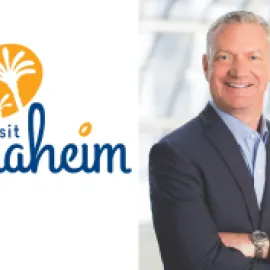 Photo of Mike Waterman standing to the right of the Visit Anaheim logo.