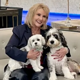 Photo of Anna Marie Presutti with two dogs on her lap.