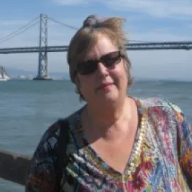 Photo of Maria Lenhart standing in front of the San Francisco Bay Bridge.