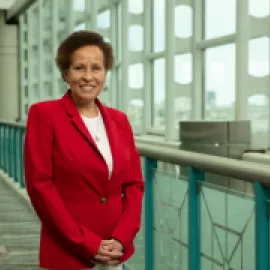 Photo of Sandi Harvey standing in a red jacket in the Atlantic City Convention Center.