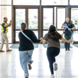Photo of two people running during a security exercise at Orange County Convention Center.
