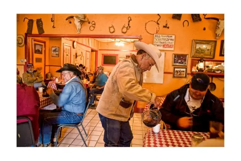 In the West Texas town of Quitaque, cowboy Tomas Hinojosa gets coffee in the Sportsman´s Café before breaking the bronc horses that work the trails of nearby Caprock Canyons State Park.