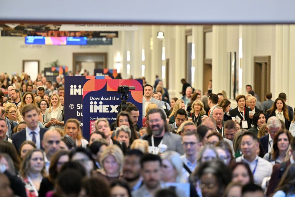 Photo of a large number of people walking into IMEX America 2023.