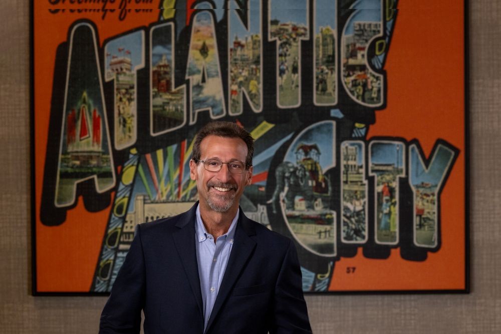 Gary Musich stands in front of Atlantic City mural