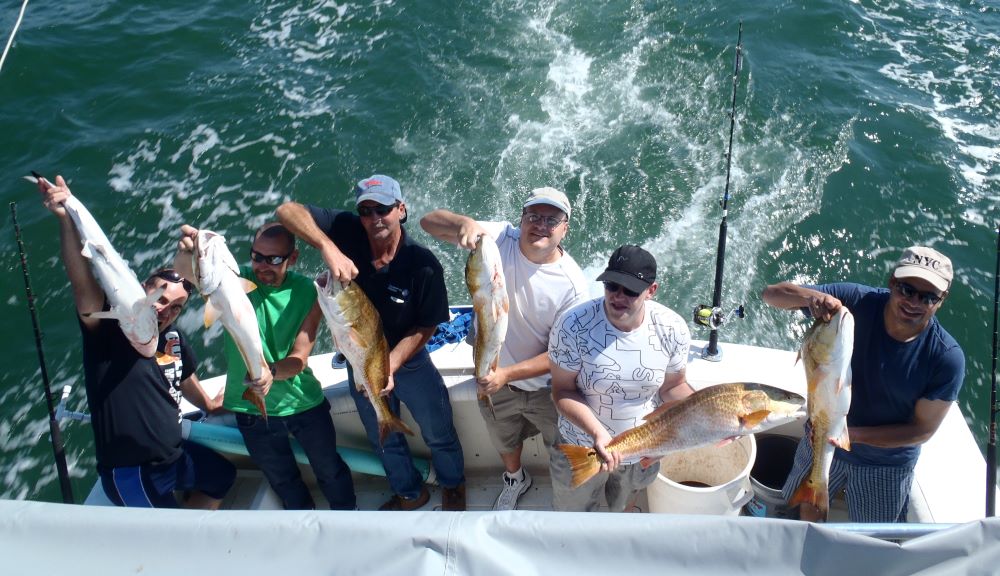 Group holding their catch of the day on their boat