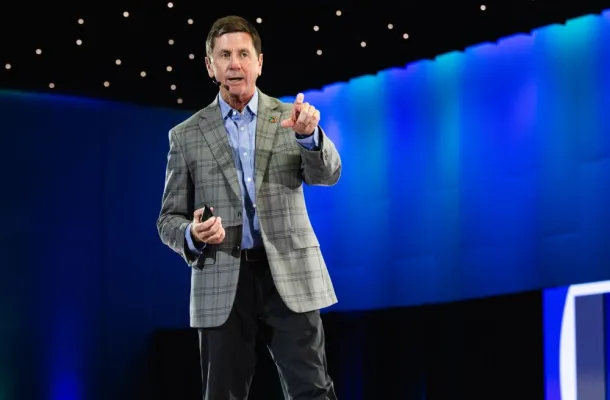 Photo of Steve O'Malley on stage, pointing at the audience.