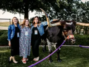 Attendees pose at Meetings Today LIVE! National next to bull in San Antonio