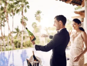 Couple popping champagne on their wedding.